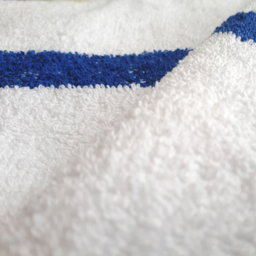 Close up image of a white towel with blue stripe. (Product Image)